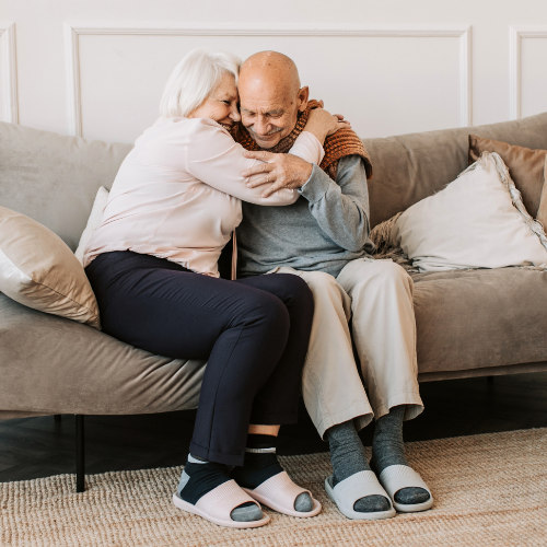 Older couple hugging on couch