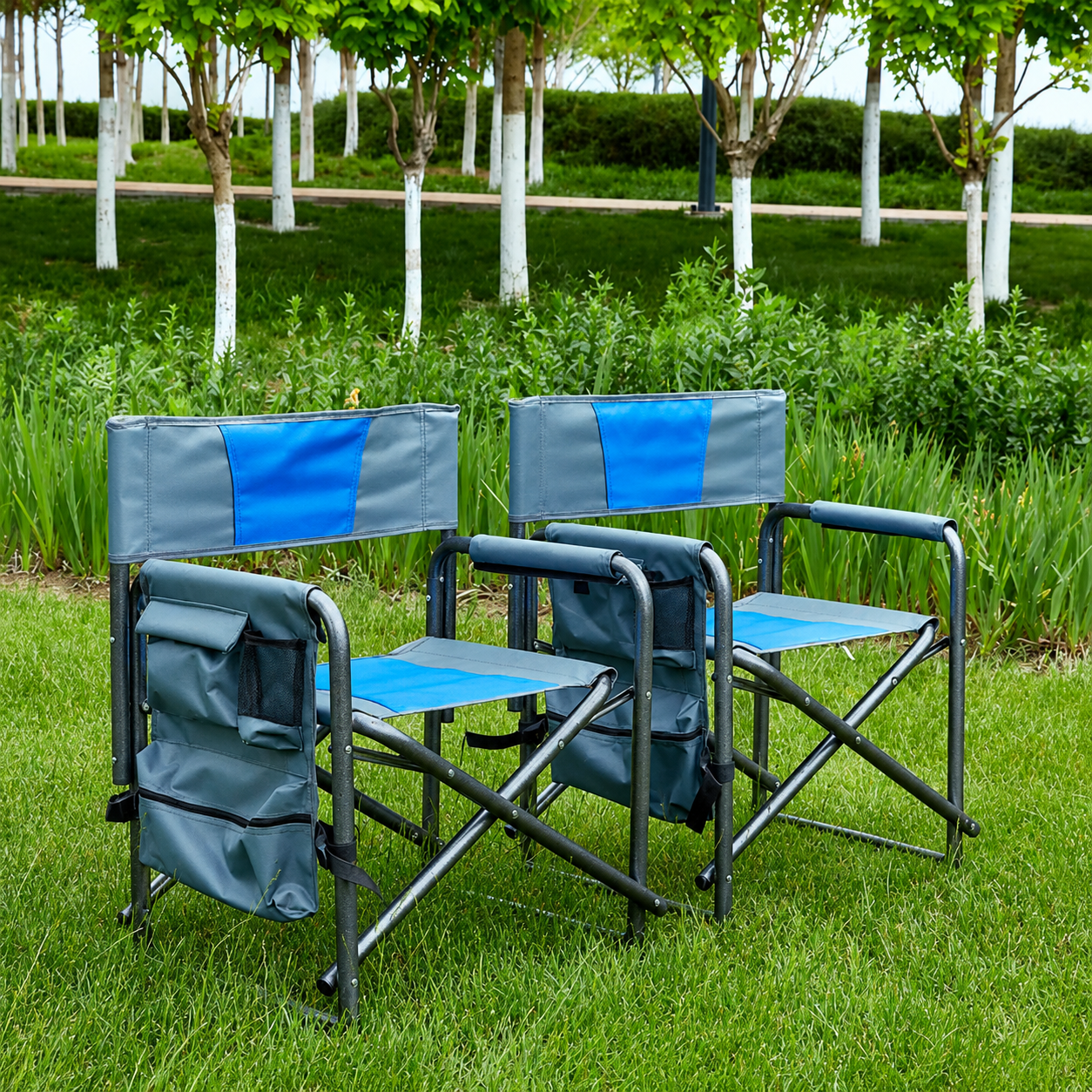 Pair of blue grey folding camping chairs set up on grass for outdoor seating