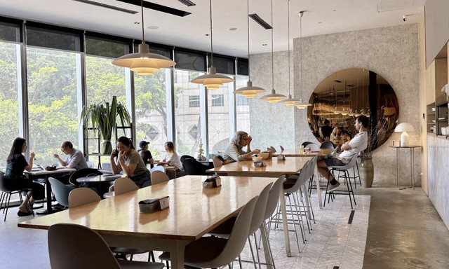 Dining area with communal tables and natural light at Real Food in Orchard Central