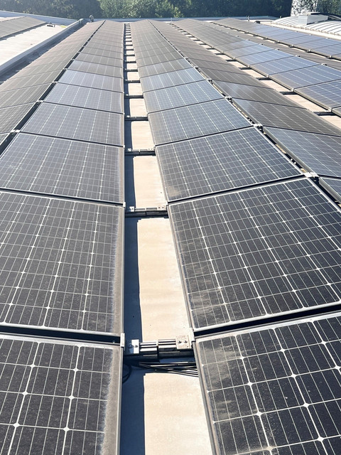 Verschmutzte Flachdach-PV-Anlage in einem Gewerbegebiet in Kierspe – dunkle Schmutzränder an den unteren Modulkanten und flächige Ablagerungen