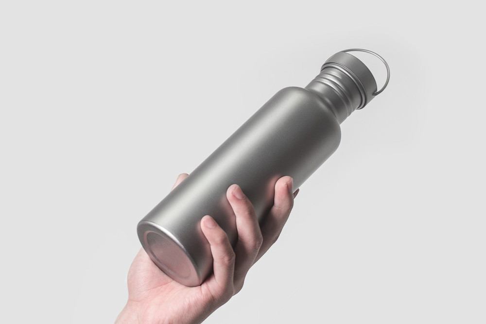 Ultralight backpacker using titanium water bottle on trail - lightweight titanium gear for hiking and outdoor adventure