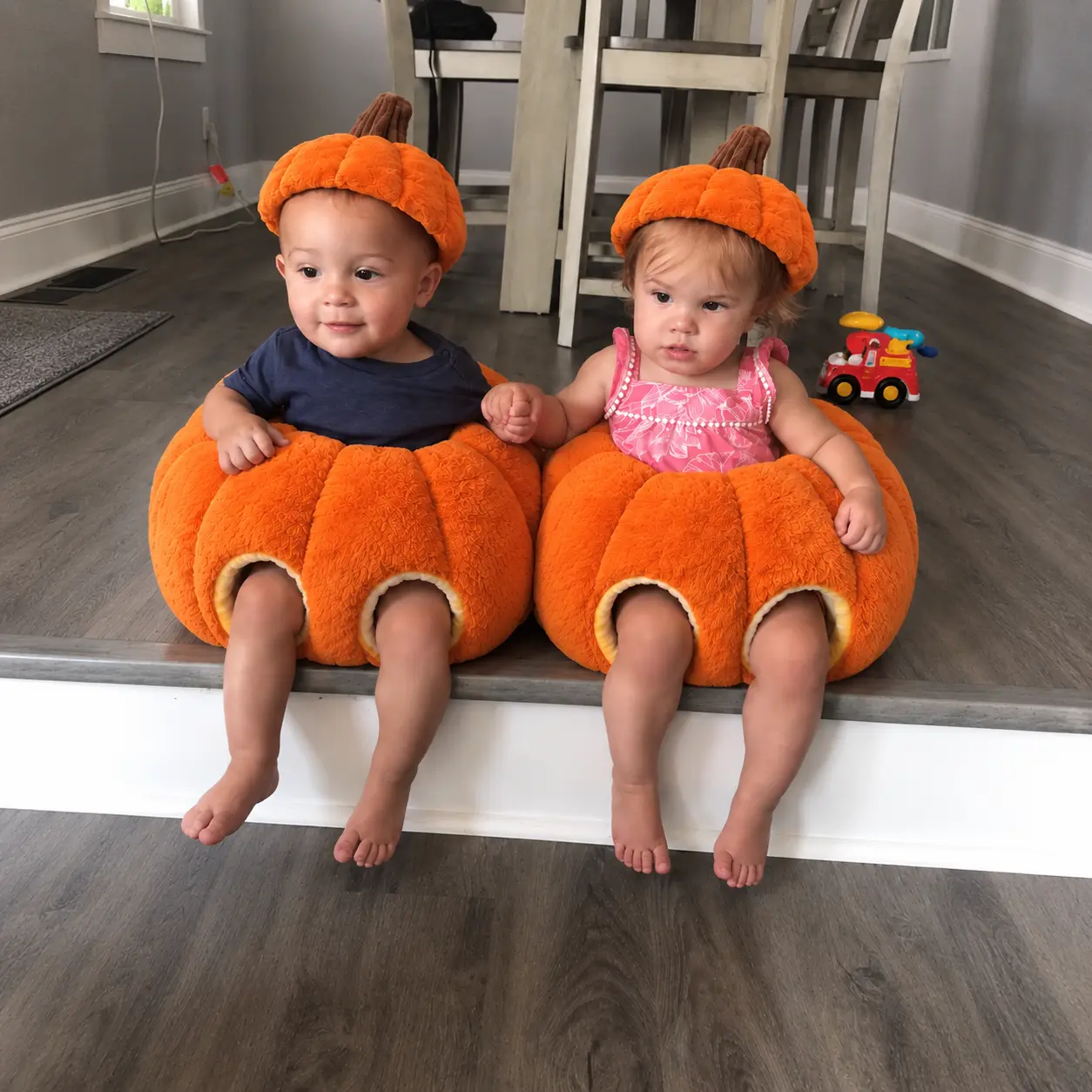 Baby sitting happily in the pumpkin seat on the floor
