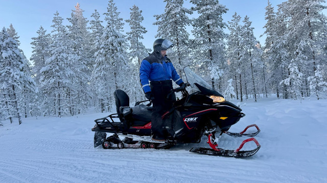 Snowmobile safari through snow-laden forest