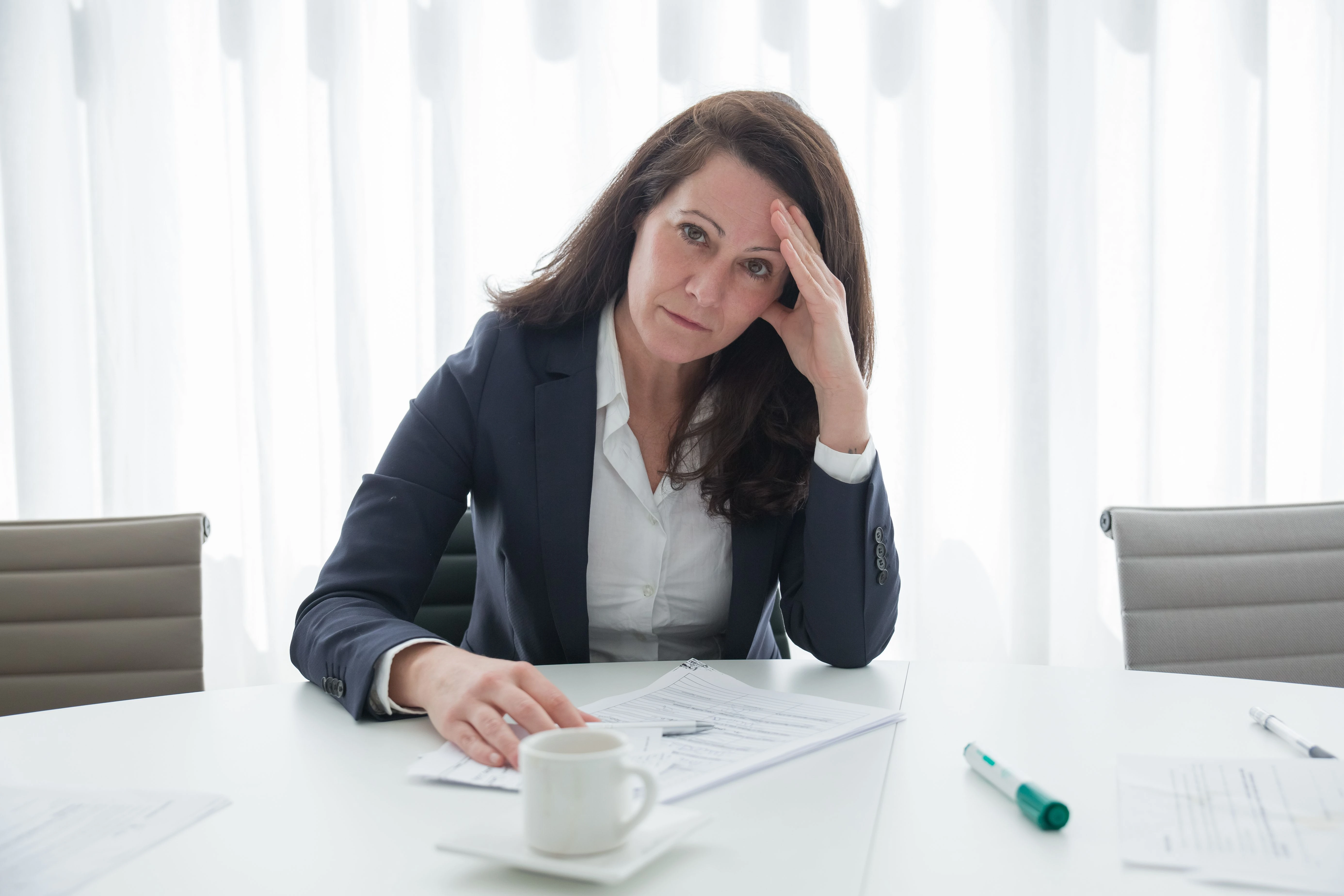 Femme pensive et concentrée, symbolisant le brouillard cérébral, la fatigue mentale et les difficultés de concentration pendant la périménopause.