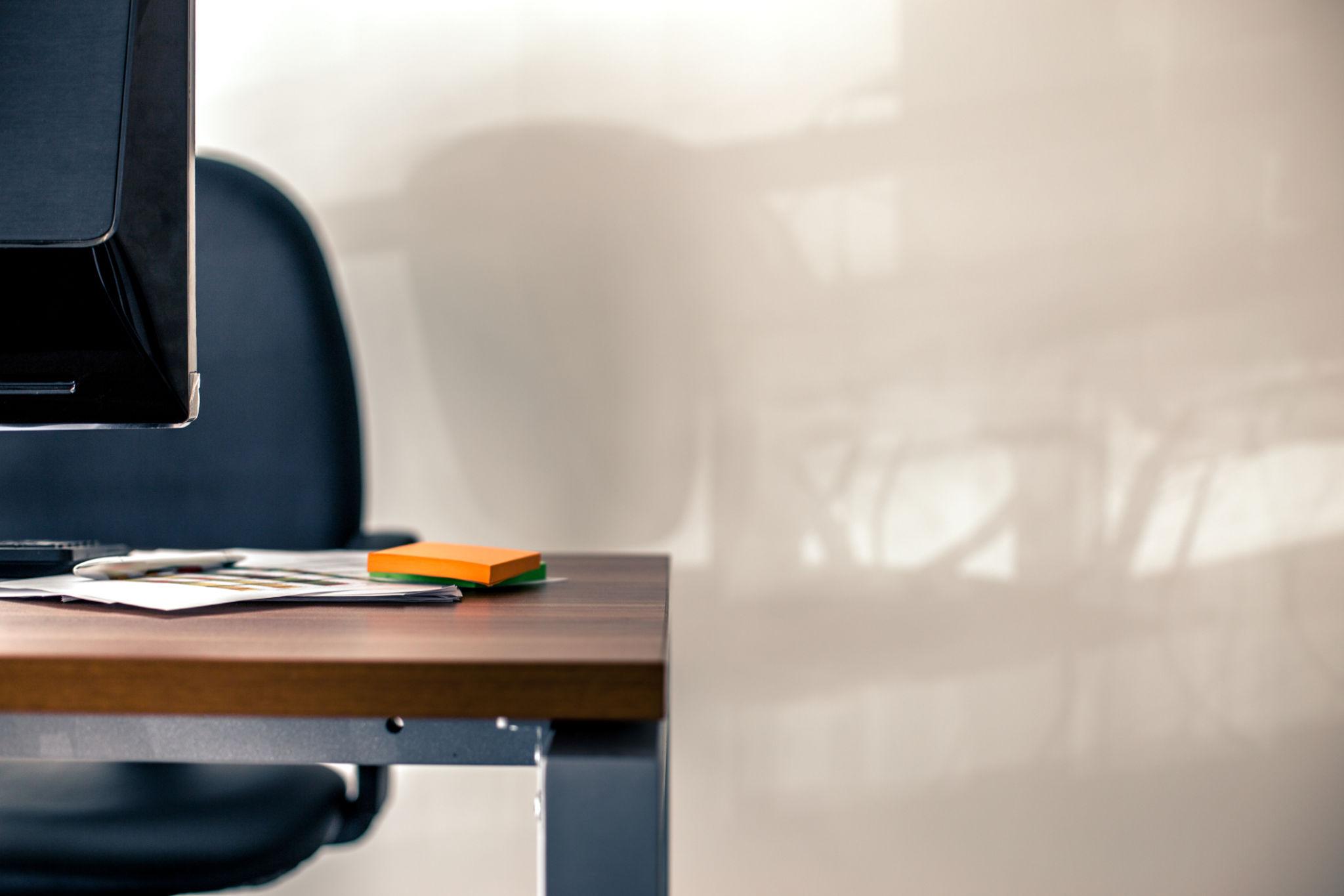 Ambiente de trabalho vazio com mesa e cadeira, representando silêncio, isolamento e impacto do ambiente sobre a saúde mental
