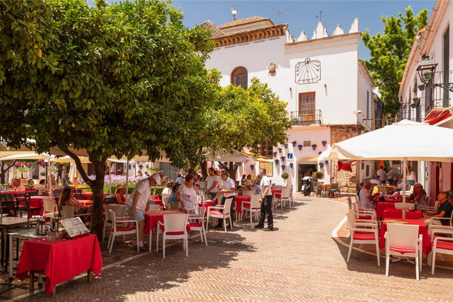 Sfeervol straatje in de Oude Stad van Marbella met traditionele Spaanse architectuur en gezellige caf&eacute;s, ervaar authentiek dagelijks leven, cultuur en gemeenschap in 2025