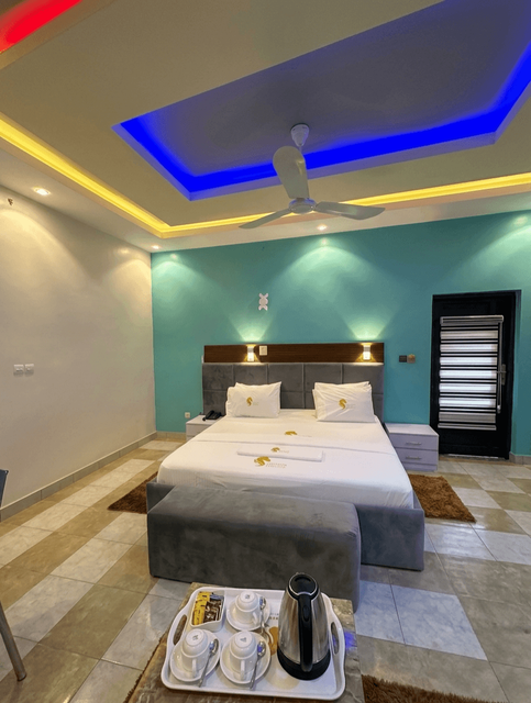 Suite Élégance hôtel Parakou Bénin – Complexe Sounon Séro, chambre turquoise moderne avec TV et bureau
