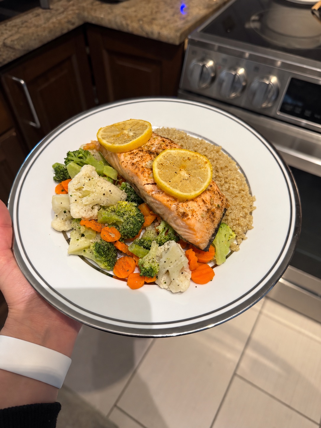 Assiette équilibrée avec un filet de saumon grillé, du quinoa, des brocolis, des asperges et une tranche de citron frais, illustrant une alimentation saine pour le cerveau.
