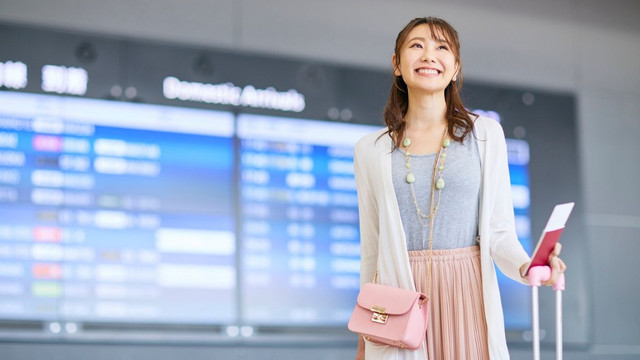 SIM利用シーン：空港で携帯電話を使う女性
