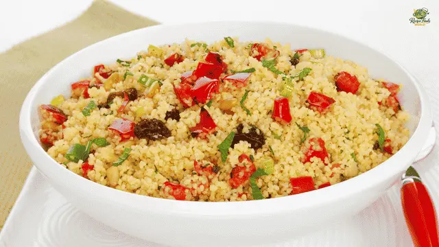 Couscous Salad Recipe Fluffy couscous salad with diced red bell peppers, raisins, and fresh herbs served in a white bowl.