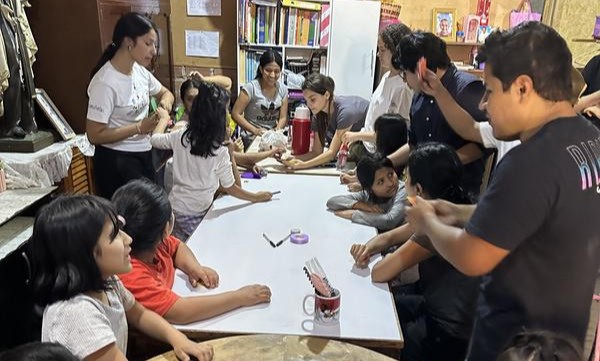 Pasantes coordinando un taller interactivo de manualidades y dibujo junto a ni&ntilde;os