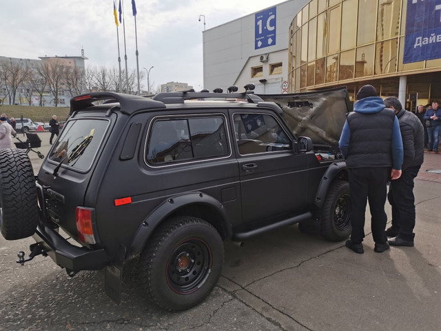 И правда, автомобиль уже показывали на прошлогодней выставке – тогда он удивил не только внешним обвесом, но и интегрированной рамой (лонжероны заменили на профильную трубу). Теперь же Нива решила похвастаться подкапотным пространством. И что же здесь такого, чего нет на обычных Нива?

Мастера из киевского ателье «Тюнинг Нива», которое специализируется на доводке машин этой марки уже 15 лет, полностью переработали моторный отсек. Уникальность в том, что у этой машины специально восстанавливали карбюраторный двигатель.Здесь стоит мотор 1,8 л, гидроусилитель, спортивный вакуум от «восьмерки», система охлаждения от «Шевроле Нивы» (не требует прокачки после замена хладагента). Появился другой карбюратор –  был «Озон», а поставили именно под объем 1,8. Плюс к этому еще раскручена голова, впуск, выпуск, применена прямоточная выхлопная система.Также установлен другой генератор, которы перенесен наверх под гидроподготовку. То есть машина может без шноркеля преодолевать глубокий брод – забор воздуха прямо с банки. Тюнингованная Нива переоборудована под газ, а потому применили польские клапана с напылением, которое устойчиво к газово-воздушной смеси. Также стоят поршни с графитовым напылением и др.Ателье «Тюнинг Нива»не останавливается на достигнутом и уже осенью собирается показать 5-дверную «Ниву» на 31-х колесах, в которой карбюраторный двигатель 1,8 будет заменен на инжекторный аналогичного объема. Также сейчас в работе находится еще одна, короткобазная Нива из 80-х. Машине полностью переварили кузов, заменили днище (появился трубчатый подрамник). Облицовка кузова здесь от «Урбана». А вот под капотом можно увидеть новый инжекторный двигатель, «саабовскую» турбину – в общем будет 125 лошадок, также появится кондиционер, система ABS.