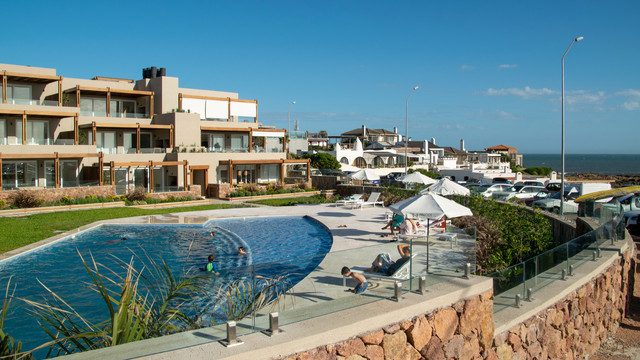Vista callejera colorida de La Barra en Maldonado, Uruguay, con tiendas boutique y arquitectura artística que reflejan el vibrante encanto bohemio costero del pueblo en 2025