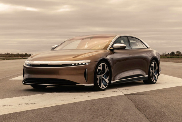 Похоже, электрический седан Lucid Air все-таки составит реальную рыночную конкуренцию Тесле Model S, причем на родной американской земле. Компания Lucid Motors начинала свою жизнь под брендом Atieva еще в 2007 году. Штаб-квартира зарегистрирована в Калифорнии, а главный инженер Питер Роулинсон прежде занимал аналогичную должность в компании Tesla. Изначально у компании были китайские корни и деньги, но в 2018 году контрольный пакет (67% акций) за 1 млрд долларов выкупил Государственный инвестиционный фонд Саудовской Аравии, и именно это вливание позволило довести первую модель до серийного вида.Снаружи готовый к производству седан Lucid Air почти не отличается от первого концепта 2016 года. Это очень крупный электромобиль: длина — 4975 мм, колесная база — 2960 мм. При этом в компании очень хорошо поработали над аэродинамикой: коэффициент Сd составляет всего 0,21. Крыша почти целиком прозрачная: лобовое стекло простирается аж до центральных стоек кузова, а над задними пассажирами врезана отдельная стеклянная секция. Air имеет два багажника: объем заднего отсека — 456 литров, переднего — 202 литра.Салон, конечно, стал попроще: у серийной версии более лаконичные обводы передней панели, традиционные передние кресла и трехместный задний диван (хотя за доплату с 2022 года будут доступны раздельные задние кресла с регулировкой спинок). Но все равно впечатляет: перед водителем расположен широкий дисплей диагональю 34 дюйма, разделенный на три тематические секции. Центральная консоль тоже целиком занята сенсорным экраном, а физические кнопки в этом салоне можно пересчитать по пальцам. В салоне восемь подушек безопасности, включая коленные для передних седоков. Предусмотрен и автопилот третьего уровня. За его работу отвечает массив из 32 датчиков, включая один фронтальный лидар.Lucid Air имеет традиционную для электромобилей компоновку с тяговой батареей под полом салона. В основе лежит собственная платформа LEAP (Lucid Electric Advanced Platform), в подвеске — обычные пружины и электронноуправляемые амортизаторы. Но главная гордость разработчиков — очень компактные и эффективные электромоторы.Агрегат массой всего 74 кг способен выдавать до 670 л.с. В компании приводят сравнение с главными конкурентами: у Теслы Model S (которая скрывается под вывеской «American EV Brand Full Size Model») мотор массой 134 кг развивает до 429 л.с., у компактной Теслы Model 3 — 92 кг и 289 л.с., а у седана Porsche Taycan («German EV Brand Performance Model») — 170 кг и 449 л.с.В семействе запланированы четыре модификации, причем базовый Lucid Air с задним приводом выйдет на рынок позже всех — в 2022 году. Характеристики еще не объявлены, зато известно, что даже такой седан будет иметь «быстрое» зарядное устройство, способное всего за 20 минут восполнить запас хода на 480 км. Базовая версия будет стоить менее 80 тысяч долларов.Версия Lucid Air Touring ожидается в конце 2021 года. У нее полный привод с двумя электромоторами суммарной мощностью 620 л.с. и аккумулятор емкостью 75 кВт∙ч. Заявленный пробег на одной зарядке — 653 км по американскому циклу EPA, максимальная скорость — 250 км/ч, время разгона до 60 миль в час (97 км/ч) — 3,2 с. За такой седан просят 95 тысяч долларов.Раньше всех, уже во втором квартале 2021 года, на рынок должны выйти самые крутые модификации. Lucid Air Grand Touring за 139 тысяч долларов — это мощность 800 л.с. и батарея емкостью 113 кВт∙ч. Заявлено, что электромобиль сможет проехать рекордные 832 км на одной зарядке, разогнаться до 97 км/ч за 3,0 с и набрать 270 км/ч.Разработчики нескромно рассчитывают, что Lucid Air станет новым ориентиром в индустрии, и уже принимают заказы и депозиты. Компания достраивает собственный сборочный завод в штате Аризона, который обошелся в 700 миллионов долларов. Первоначальная мощность предприятия составляет всего 20 тысяч машин в год, но в ближайшей перспективе она будет увеличена до 130 тысяч, а в дальнейшем проект предусматривает расширение до 380 тысяч машин в год.