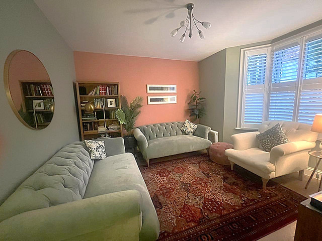 Living room with coral accent wall — East London