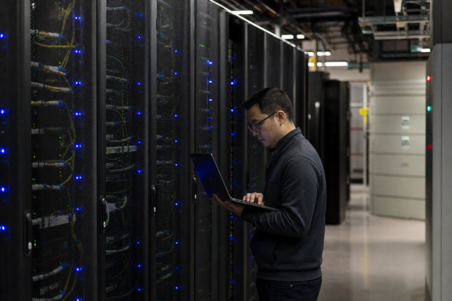 A corporate data center server room with rows of glowing racks representing AI infrastructure, financial technology documentary photography