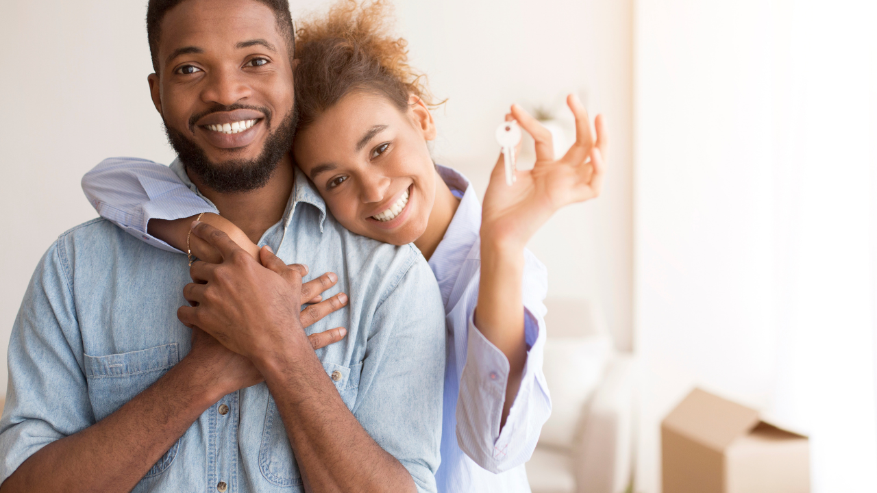 Happy couple holding keys to new rental home