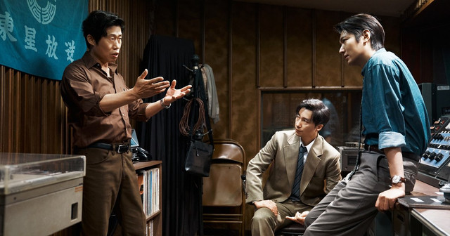 영화 암살자(들) 스틸컷, 1970년대 방송국 사무실에서 이야기하는 세 인물