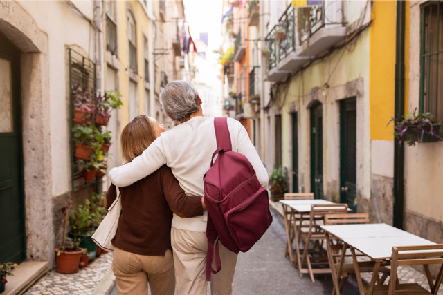 Senior expat couple enjoying a scenic coastal view in Southern Europe – representing relaxed retirement lifestyle and affordable living in Portugal and Spain.