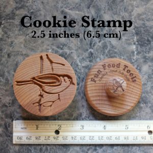 Wooden cookie stamp measured next to a ruler approximately 2.5 inches across