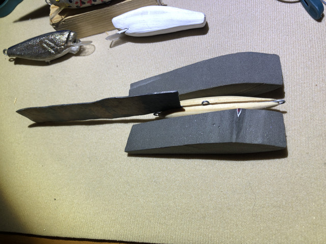 Detalle del plomo machacado para insertarlo en la ranura y poder equilibrarlos con menos ajustes y sin variación y dos recortes cortesía de un paisano mío de fibra de vidrio de un alerón de coche la pregunta es si valdrían para realizar señuelos en nada me pongo a ello y la otra duda si es mejor inmersión en barniz de yate o el époxi cual gana en dureza resistencia y acabados gracias saludos buena pesca