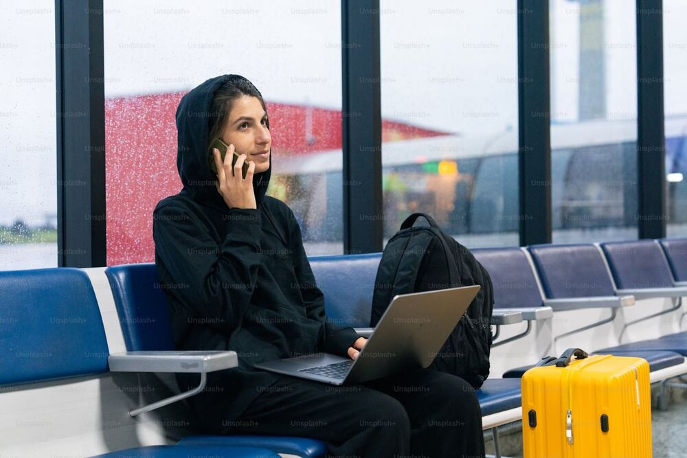 a woman sitting on a bench talking on a cell phone