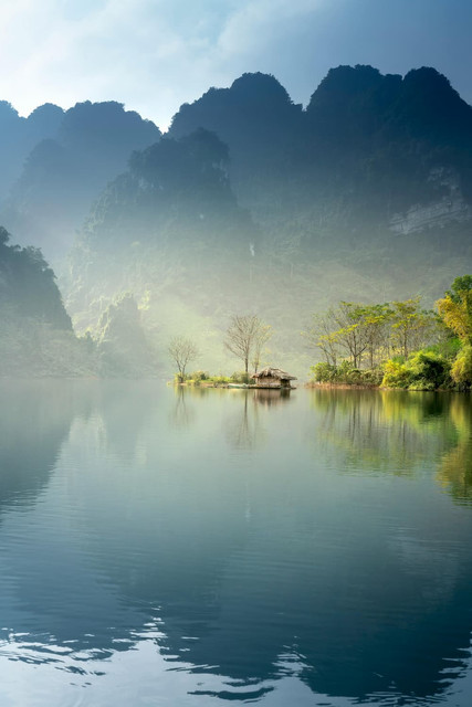 Tropical misty lake with towering mountains