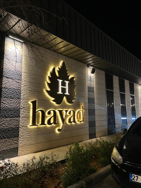 Backlit acrylic business sign with warm glow on storefront