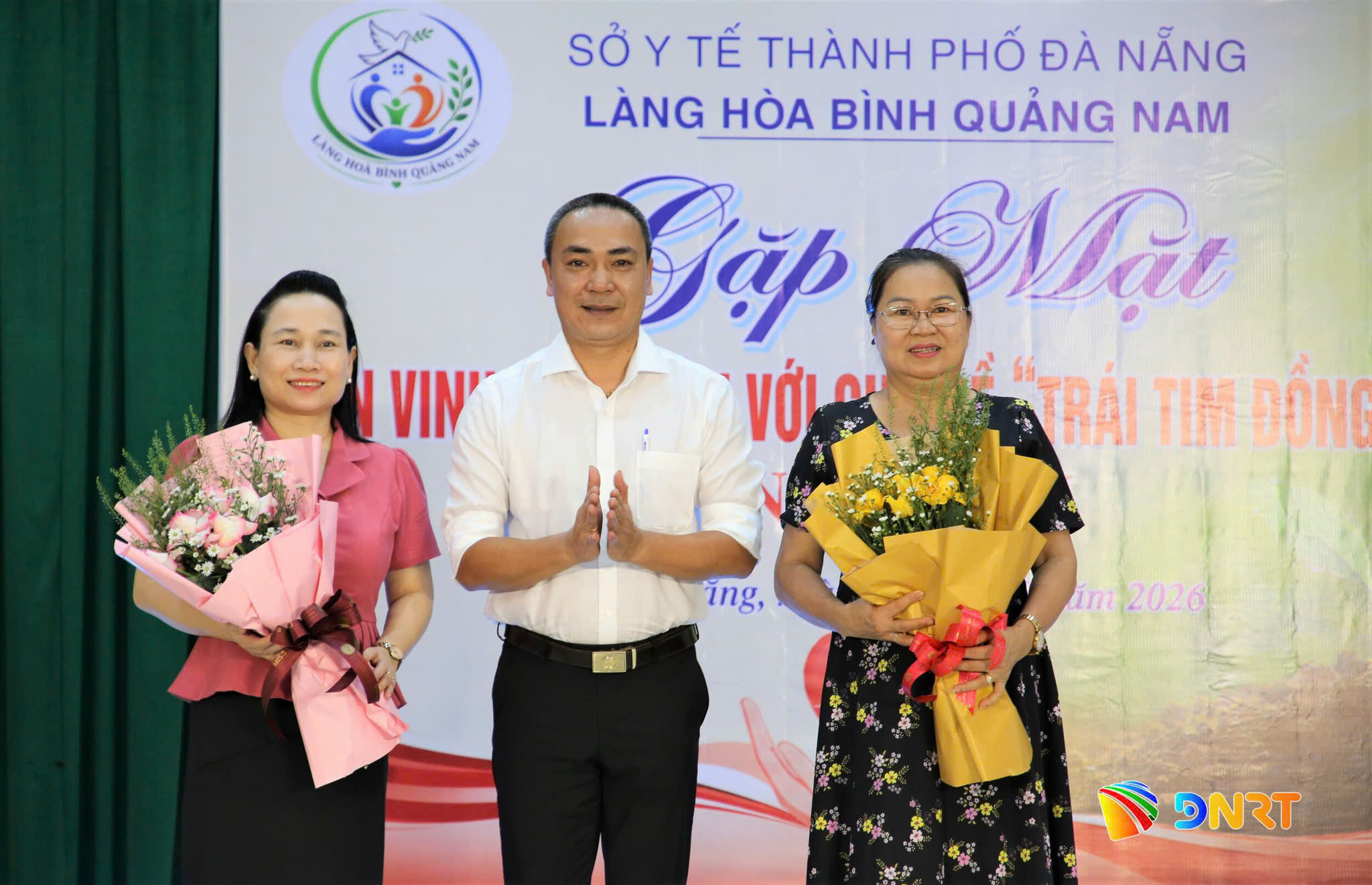 Giám đốc Làng Hòa Bình Quảng Nam Nguyễn Thành Trung (giữa) tặng hoa tri ân nguyên lãnh đạo Sở Lao động - Thương binh và Xã hội tỉnh Quảng Nam (bên phải) và bà Đoàn Thị Hoài Nhi, Phó Giám đốc Sở Y tế thành phố Đà Nẵng (bên trái). Ảnh: ALĂNG NGƯỚC