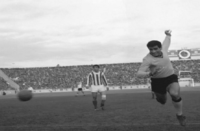 1968, η ΑΕΚ αντιμετώπιζε τον Ολυμπιακό για την 5η αγωνιστική του πρωταθλήματος στο «Καραϊσκάκη», όπου έμελλε να πάρει παλικαρίσιο «διπλό».
Ένα άσχημο ξεκίνημα στην έναρξη της σεζόν για την ΑΕΚ στο πρωτάθλημα με μία ισοπαλία και δύο ήττες, θα σταματούσε με μία μεγάλη νίκη μέσα στο γήπεδο του Ολυμπιακού.
Η αναμέτρηση εξελίχθηκε ιδανικά για τους κιτρινόμαυρους καθώς στο 12’ είχε δοκάρι με τον Παπαϊωάννου και δυο λεπτά αργότερα, ο Νικολαΐδης έδωσε το προβάδισμα στην Ένωση, μετά από σουτ.
Στο 30’ ο Σιδέρης ισοφάρισε με κεφαλιά για τον Ολυμπιακό, λίγο πριν υπάρξει η πρώτη… ερυθρόλευκη κλάψα, για το πέναλτι που δόθηκε στον Καραφέσκο. Οι ερυθρόλευκοι διέκοψαν για 12 λεπτά τον αγώνα επειδή διαμαρτύρονταν στον διαιτητή, όπου του έσκισαν και την μπλούζα.
Τελικά ο Καραφέσκος εκτέλεσε το πέναλτι εύστοχα, κάνοντας το 1-2, που ήταν και το σκορ ημιχρόνου, ενώ οι Πειραιώτες είχαν μείνει με παίκτη λιγότερο. Το δεύτερο ημίχρονο ξεκίνησε με τους ερυθρόλευκους να ισοφαρίζουν στο 63’, με τον Σιδέρη.
Από εκεί και πέρα τη παράσταση έκλεψε, ο πολύ καλός στην αναμέτρηση, Μίμης Παπαϊωάννου. Στο 78’, με απευθείας φάουλ, νίκησε τον αντίπαλο τερματοφύλακα και έκανε το 1-3. Στο 86’, η ΑΕΚ μένει δίχως τερματοφύλακα και στην θέση αυτή μπαίνει ο Παπαϊωάννου, μετά από απόφαση του κιτρινόμαυρου προπονητή.
Ο προπονητής της ΑΕΚ είχε δικαίωμα αντικατάστασης με τερματοφύλακα ,καθώς λίγους μήνες πριν είχαν καθιερωθεί αλλαγές στο ποδόσφαιρο, όμως επέλεξε να δώσει τα γάντια στον Μίμη, ο οποίος έκανε δυο θαυμάσιες αποκρούσεις.
Η ερυθρόλευκη… κλάψα όμως δεν σταμάτησε στην λήξη της αναμέτρησης (2-3), αλλά συνεχίστηκε με την ένσταση που κατέθεσαν επειδή ανέφεραν πως τα 15 τελευταία λεπτά του αγώνα διεξήχθησαν χωρίς ανάλογο φωτισμό.