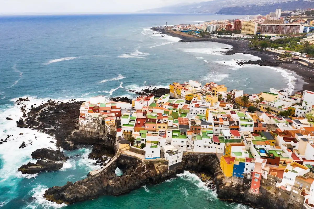 Colorful Rooftop Village Clings to Volcanic Coast