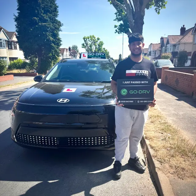 GO-DRV student Aryan L. holding pass board celebrating 1st time automatic driving pass in Wolverhampton