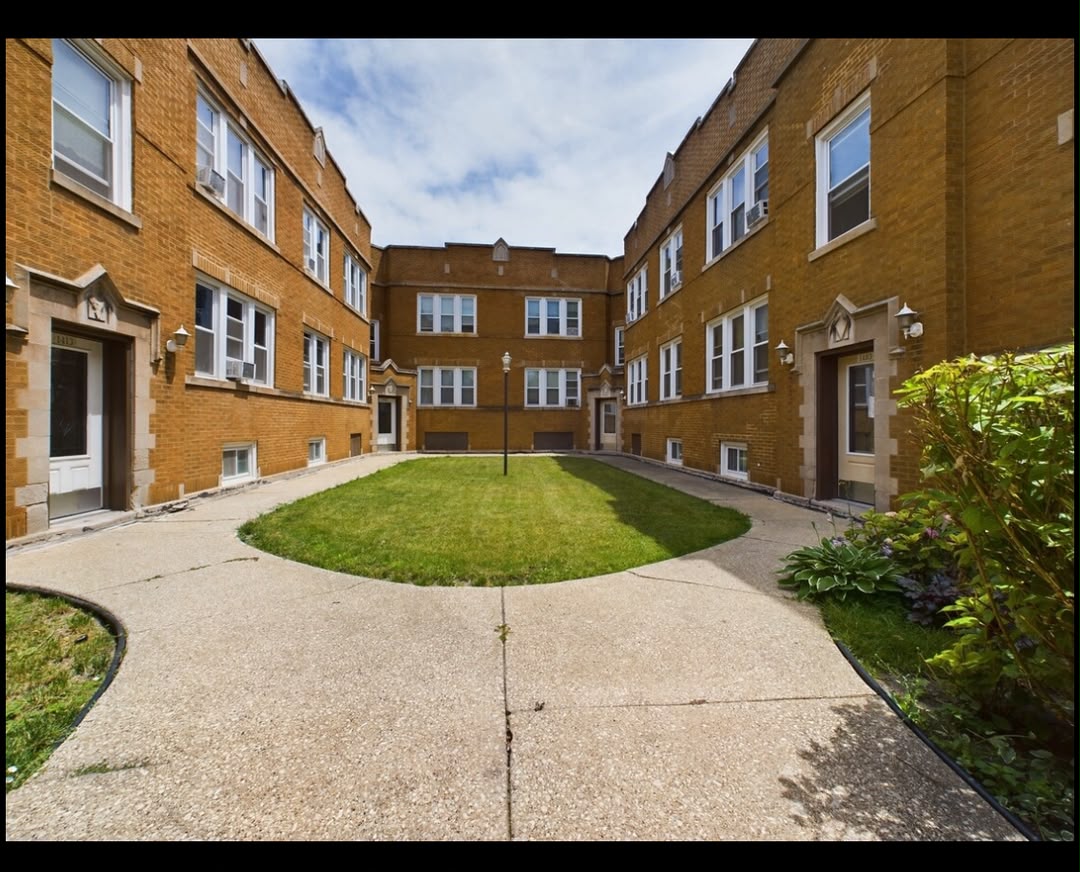 Brick multifamily property on a sunny residential street