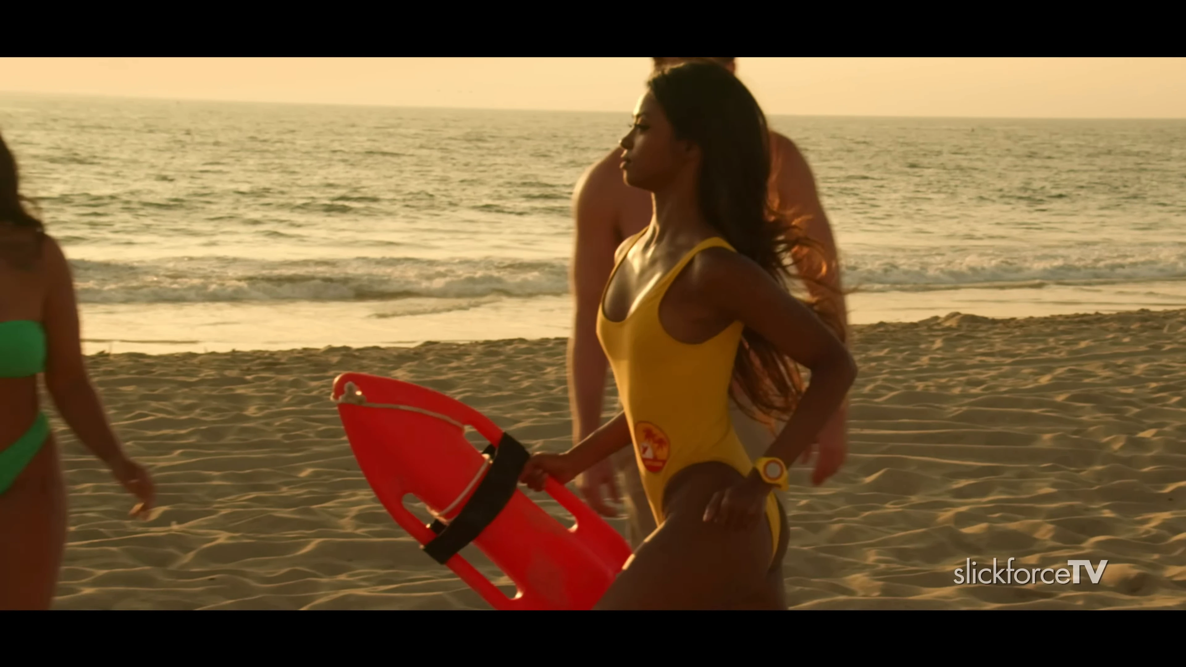 Shaun Romy posing confidently in a yellow bikini by the pool, showing off her toned figure
