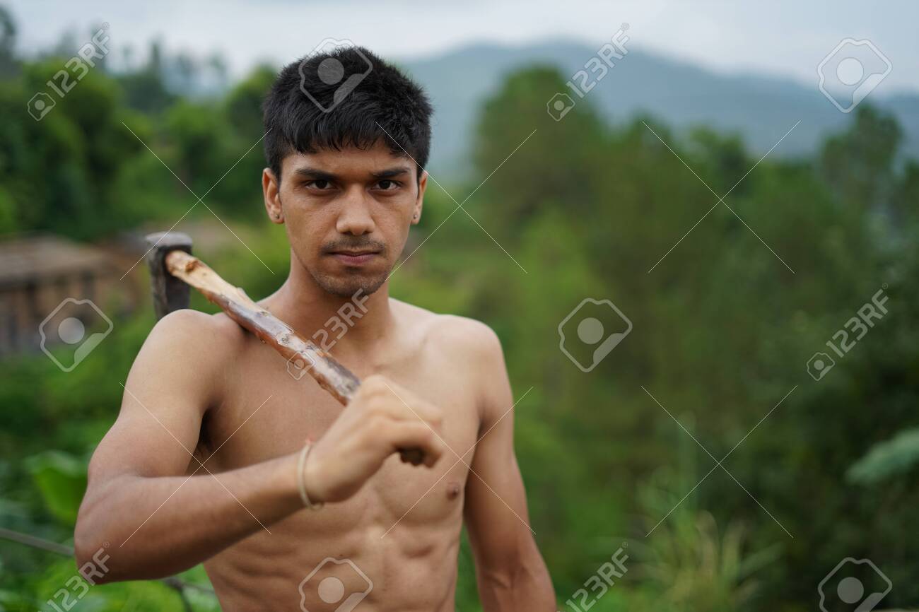 Young-handsome-shirtless-boy-holding-axe-in-his-hands