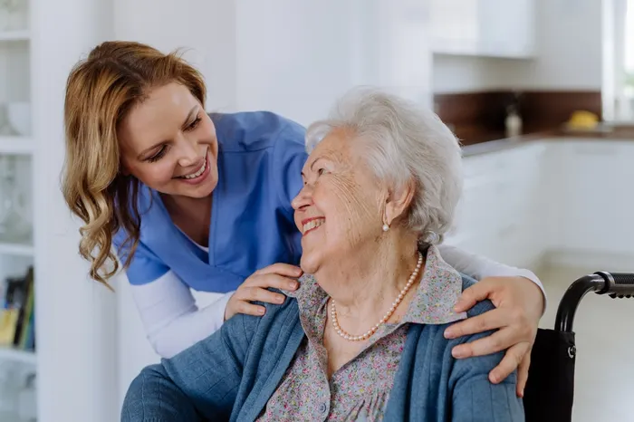 A Caring Hearts support worker smiling with an older woman in her SDA home in Melbourne