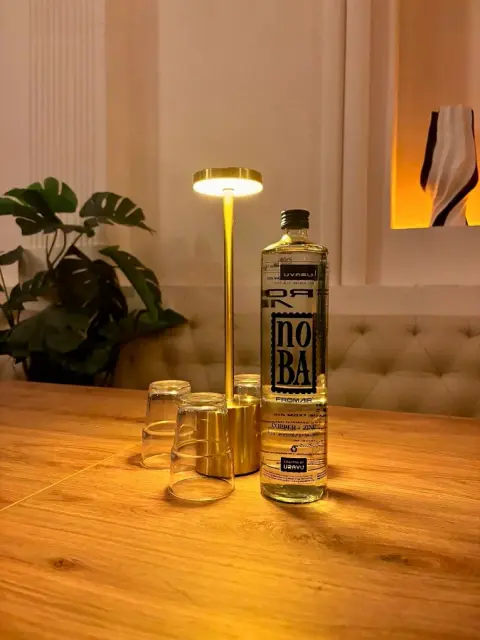 Intimate evening ambiance with brass table lamp at NOBA