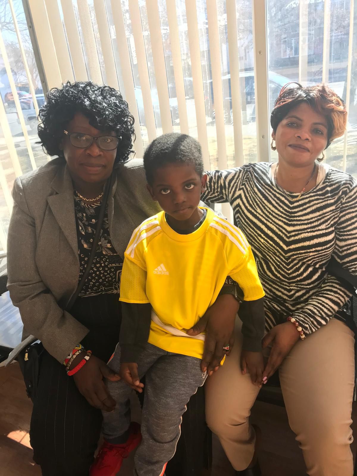 This photo captures Jane Kinity, CEO of New International Hope for Refugees and Immigrants, providing language support at Yale New Haven Hospital. She is assisting a mother and her young son, helping bridge communication between the family and medical staff.