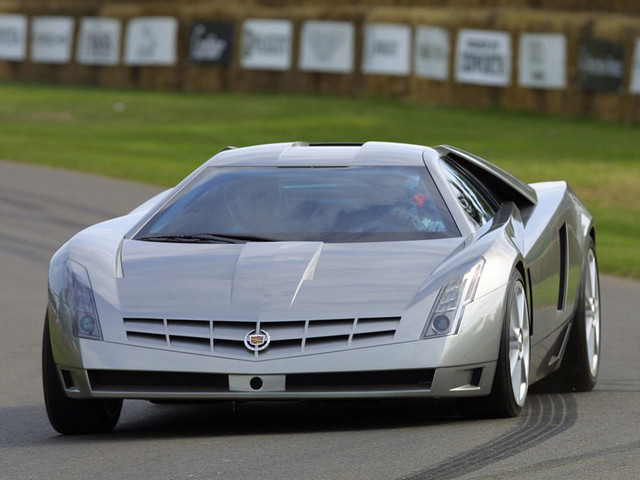 Концепт-кар Cadillac Cien Concept был выпущен в 2002 году. Его название переводится с испанского как «сто», а с французского как «небо». Стоит отметить, что это не серийный автомобиль, а скорее прототип, который должен был стать флагманом среди спорткаров компании. Его задачей было сформировать новый облик спортивной линейки Cadillac, а также отметить своим появлением на свет столетний юбилей автопроизводителя.

Cien относится к классу luxury и может взять на борт четыре человека. Его длина составляет 5 174 миллиметра, ширина 1 968 и высота 1 270 миллиметра. Вес 1 400 килограмм в полностью снаряжённом состоянии.

Что касается технической начинки, то силовая линейка представлена здесь двигателем V12 DOHC рабочим объёмом 7.5 литра. Так как производитель выбрал для этой модели среднемоторную компоновку, двигатель можно прекрасно рассмотреть через прозрачную крышку моторного отсека размещённую сзади.

V12 DOHC использует в своей работе систему HEMI, которая позволяет водителю отключить до половины всех цилиндров, что позволяет существенно экономить топливо. Кроме того на вооружении этого спорткара имеется также система FSI и комбинированный стартёр-генератор.

Стоит также отметить, что здесь применена система непосредственного впрыска топлива и два турбонагнетателя поэтому мотор суперкара может выдать 750 лошадиных сил. При этом он изготовлен полностью из алюминия и работает совместно с шестиступенчатой полуавтоматической коробкой передач. Автомобильные эксперты отмечают необычный момент, дело в том, что Cadillac Cien Concept на сто единиц мощности тратит всего лишь один литр топлива. Такой показатель экономичности весьма необычен для американской автомобильной промышленности.

Дизайн спорткара футристичен. Его создают чёткие прямые линии и тёмный цвет окраски кузова, который изготовлен из углеродного пластика. Такой ход позволяет также значительно уменьшить общий вес автомобиля, именно по такому принципу построены кузова гоночных болидов и кабины самолётов-истребителей.

Кроме того на Cien Concept широко применены различные аэродинамические элементы. В частности это активный спойлер автоматически меняющий своё положение в зависисмоти от скорости развиваемыой автомбилем,и широкие воздухозаборники размещённые по бокам. Также отличительной деталью экстерьера данной модели является массивная радиаторная решётка в классическом стиле Cadillac.

Что же касается салона, то он полностью оправдывает устоявшиеся представления о роскоши, символом которого является в автомобильном мире Cadillac. Так, например, он оснащён спутниковой системой бизнес-связи OnStar, сонарной системой парковки, устройством контроля стабилизации автомобиля во время движения, а также механизмом голосового управления названных систем.

Кроме того, во время езды водитель суперкара имеет возможность видеть проецируемое на лобовое стекло изображение дороги на тот случай, когда видимость резко ухудшается при передвижении по трасе ночью.

Салон отделан в стиле «хай-тех» при этом сохранена роскошь в виде применения в качестве отделочного материала натуральной кожи, пластика, а также изготовленных из алюминия различных отделочных элементов. Кроме того, к услугам пассажиров второго ряда предоставлен встроенный хьюмидор предназначенный для хранения сигар.

Примерная цена Cadillac Cien Concept составляет 3 000 000 долларов. При этом стоит отметить, что серийно автомобиль не выпускается и на сегодня его единственный экземпляр храниться в частной коллекции.

Технические характеристики
Год:2002
Двигатель:7500 см³
Мощность:750 л.с.
Скорость:350 км/ч
Разгон 0-100 км/ч:3,5 сек
Крутящий момент:611 Нм
Вес авто:1400 кг
Компоновка:Среднемоторная
Тип привода:Задний
Тип двигателя:V12
Цена $:3 000 000