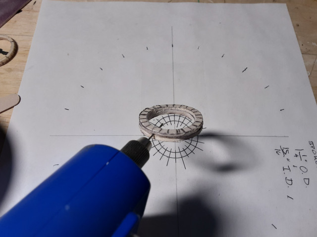 Using a 1/32" bit, drill holes through the wheel.