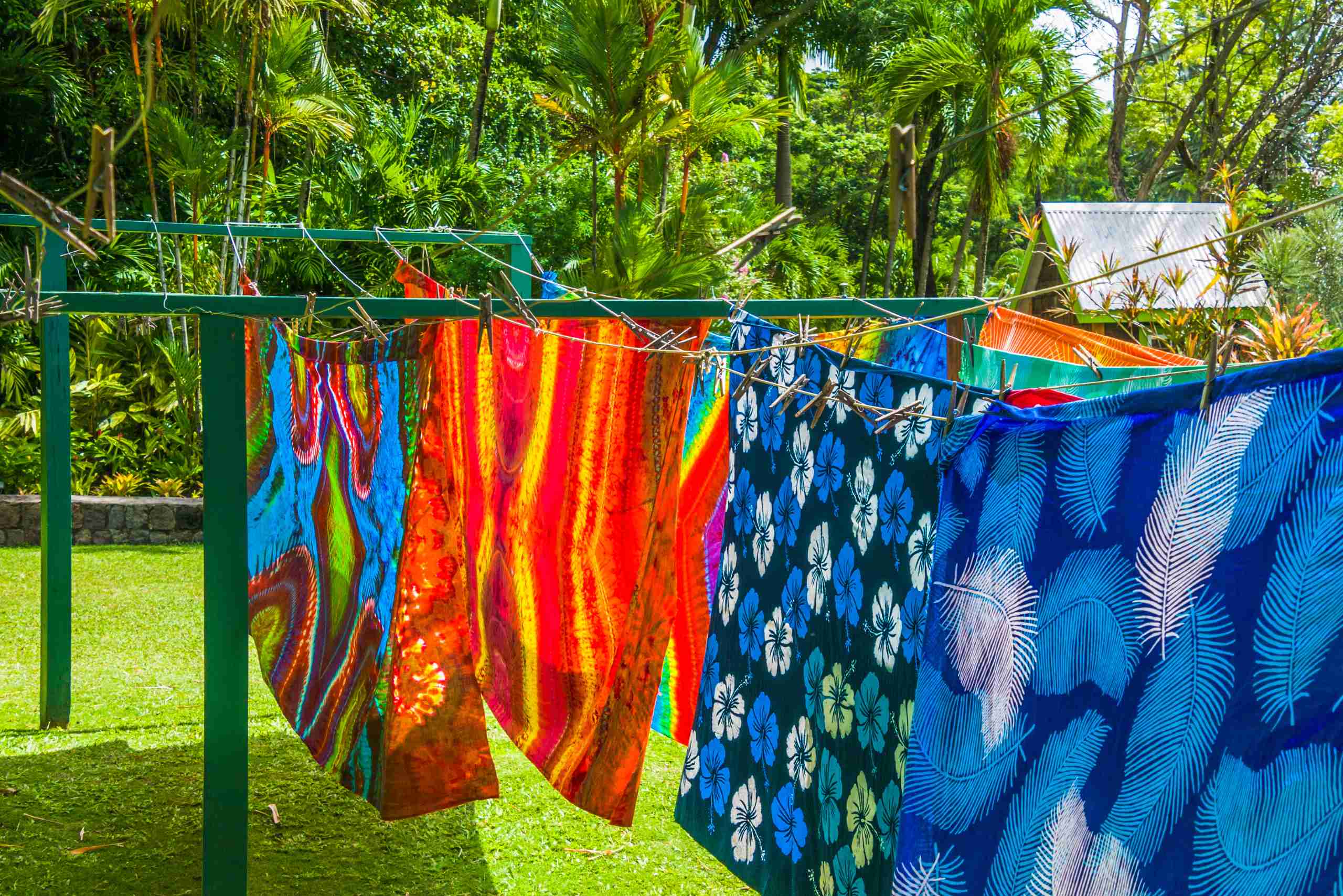 An image showing colourful dyed fabrics drying on a clothesline.