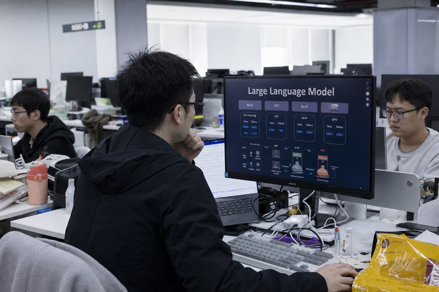 A modern Chinese technology research laboratory with engineers working at terminals on a large language model, documentary news photography,