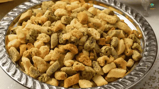 Moroccan Krichlate Recipe Large silver platter filled with an assortment of small, crunchy Moroccan Krichlate savory and sweet cookies.