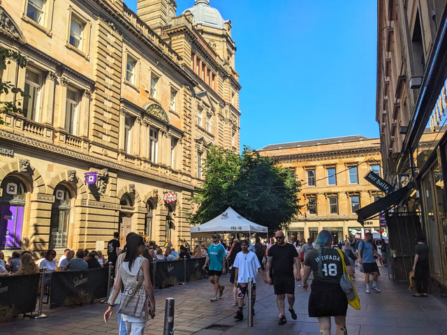 Pedestrians and outdoor dining on Gordon Street, Glasgow city centre, with Victorian architecture, highlighting the vibrant lifestyle for international buyers relocating to the UK.