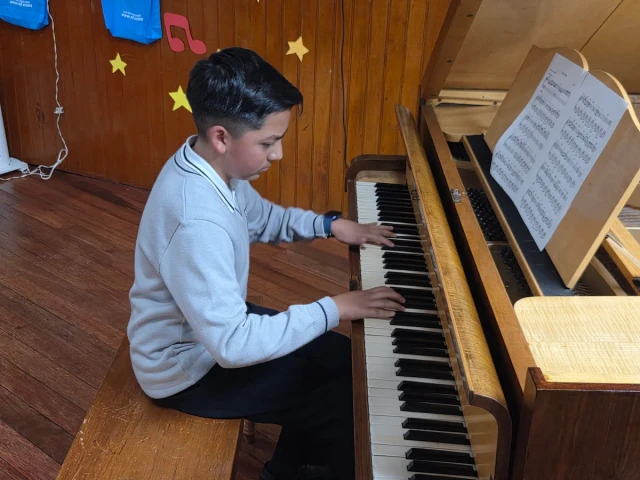 Estudiante interpretando una pieza musical en el piano