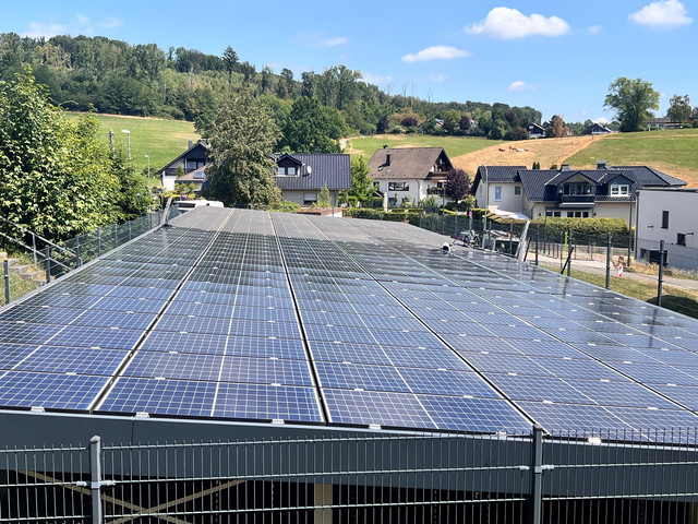 Freiflächen-PV-Anlage der Gemeinde Lindlar während der Reinigung – vordere Modulhälfte gereinigt, hintere noch verschmutzt