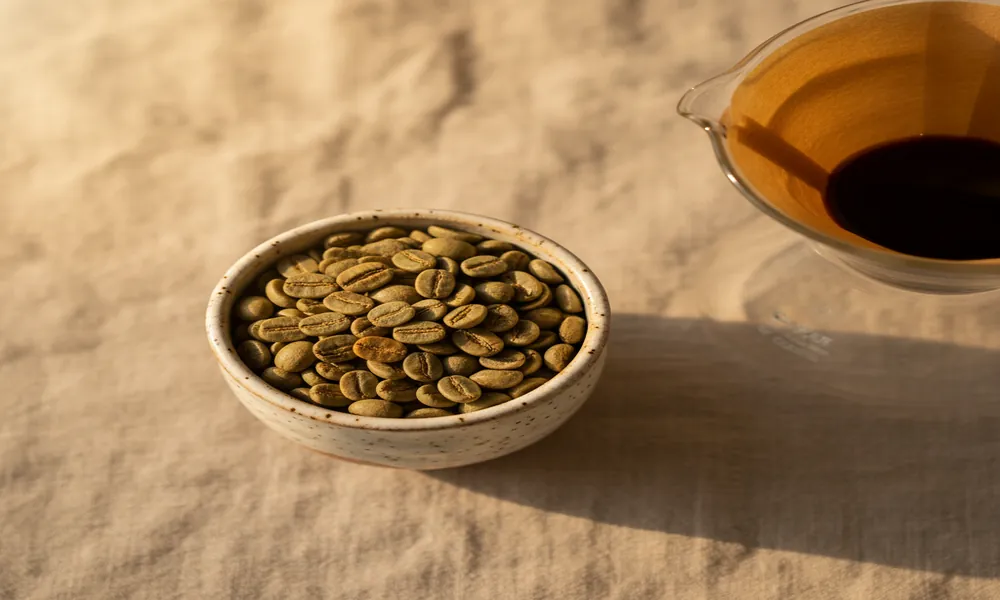 Grãos claros de Typica etíope em cerâmica artesanal com Clever Dripper ao fundo