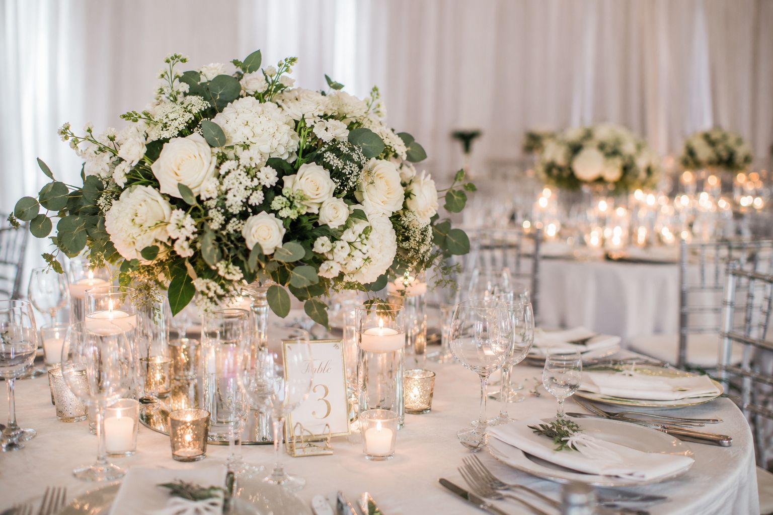 Elegant luxury wedding table with white floral centrepiece and candles by Zen Events