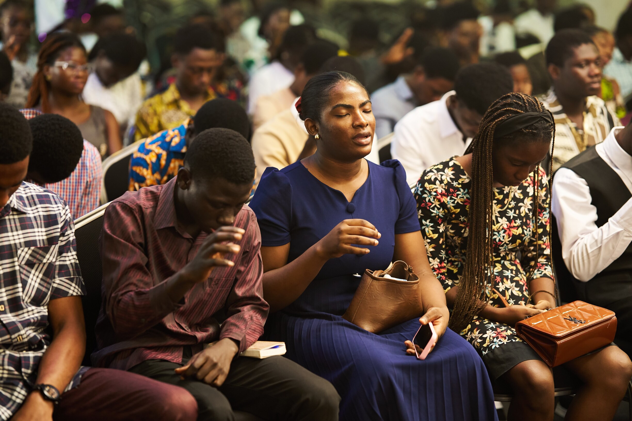 Members of the assembly lifting their hands in worship